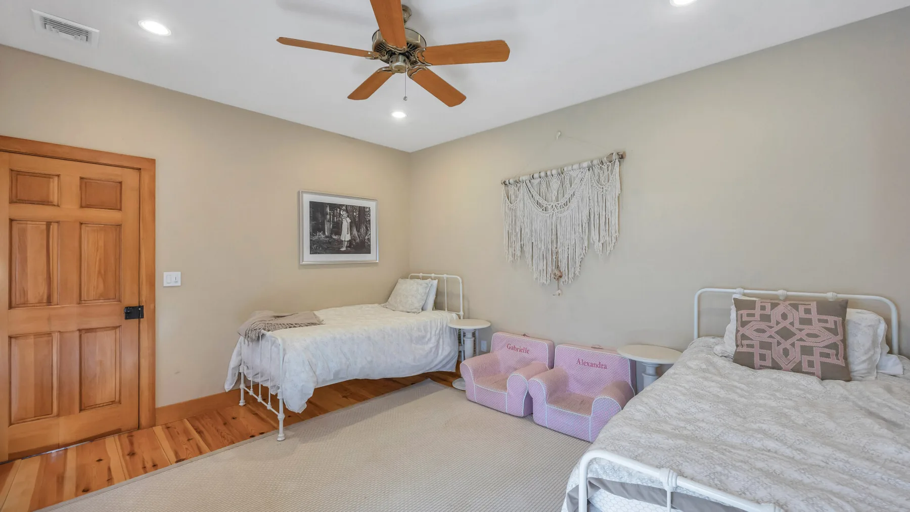Un dormitorio con dos camas y un ventilador de techo.