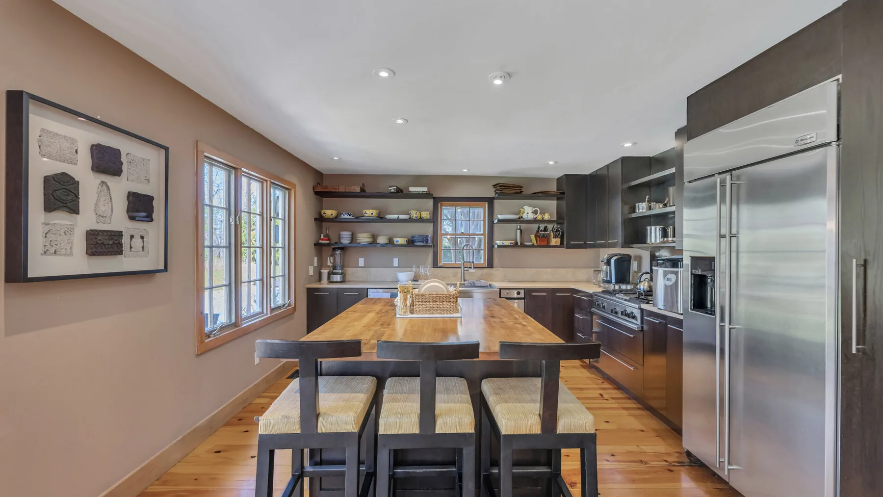 Una cocina moderna con una isla larga de madera y electrodomésticos de acero inoxidable.