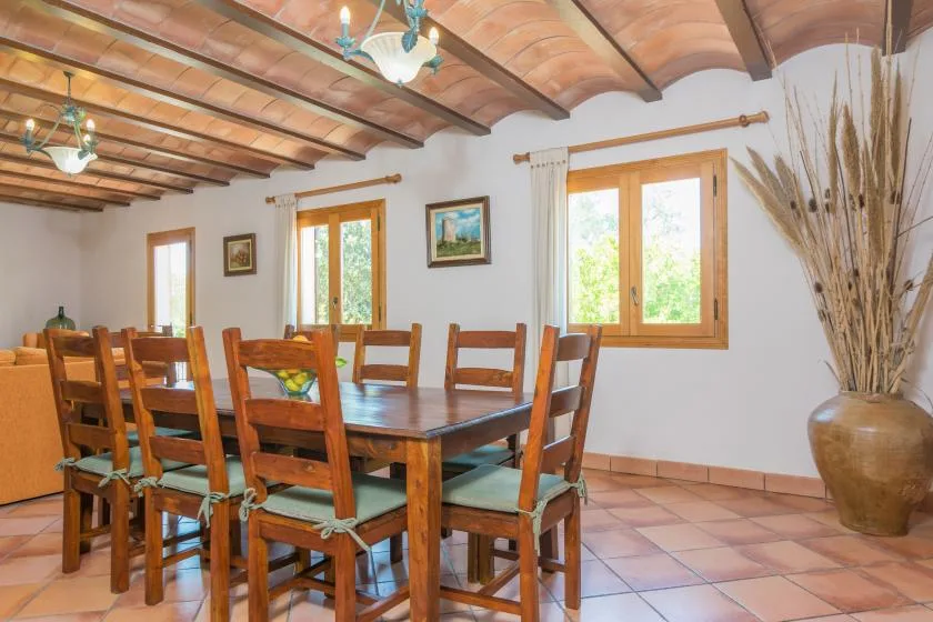 Un comedor con una mesa y sillas de madera bajo vigas expuestas.