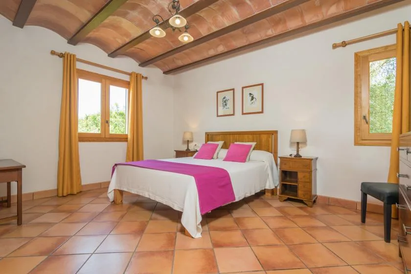 Un dormitorio con una cama doble vestida con ropa de cama blanca y rosa intenso.