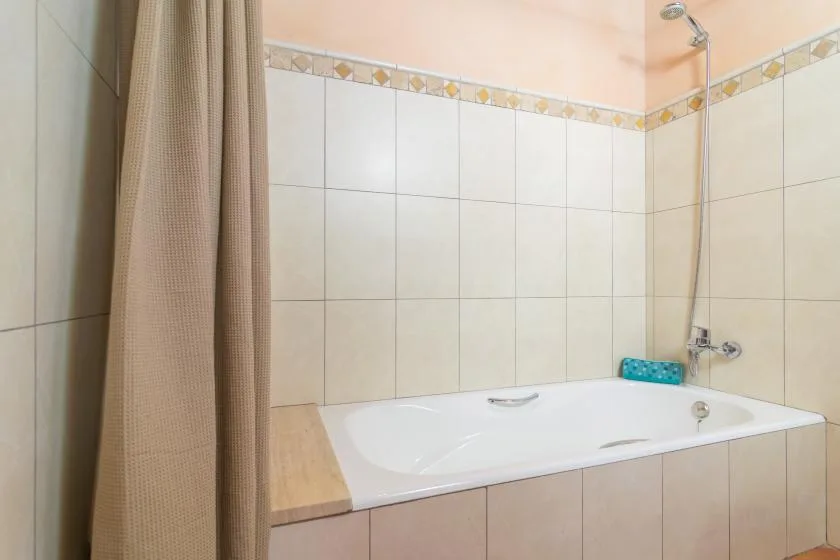 Un baño alicatado con bañera y ducha.