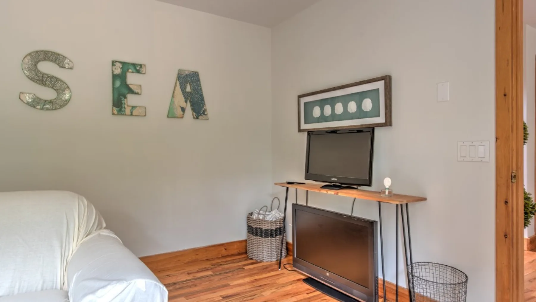 Un dormitorio con una cama, un televisor y letras decorativas en la pared.