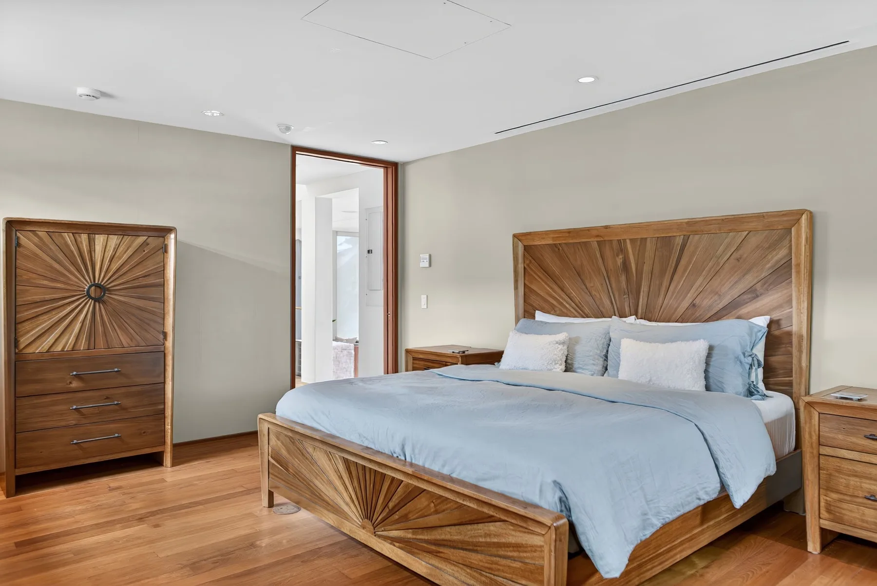 Un dormitorio con una cama de madera y ropa de cama azul claro.