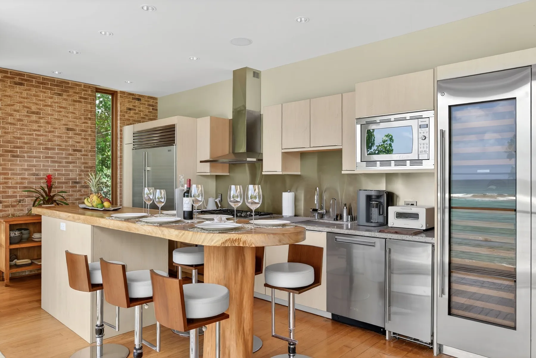 Una cocina moderna con una isla larga y electrodomésticos de acero inoxidable.
