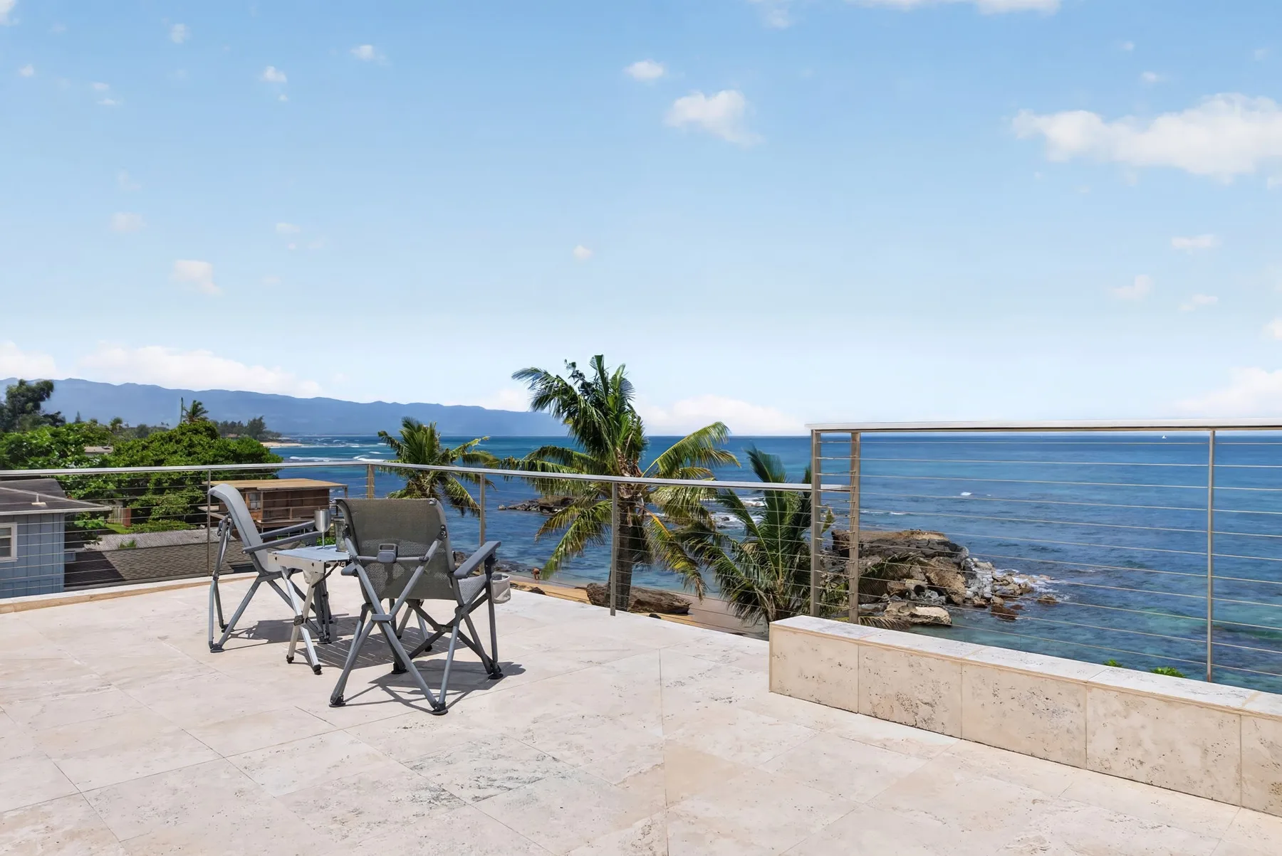 Una terraza junto al mar con asientos al aire libre da al agua.