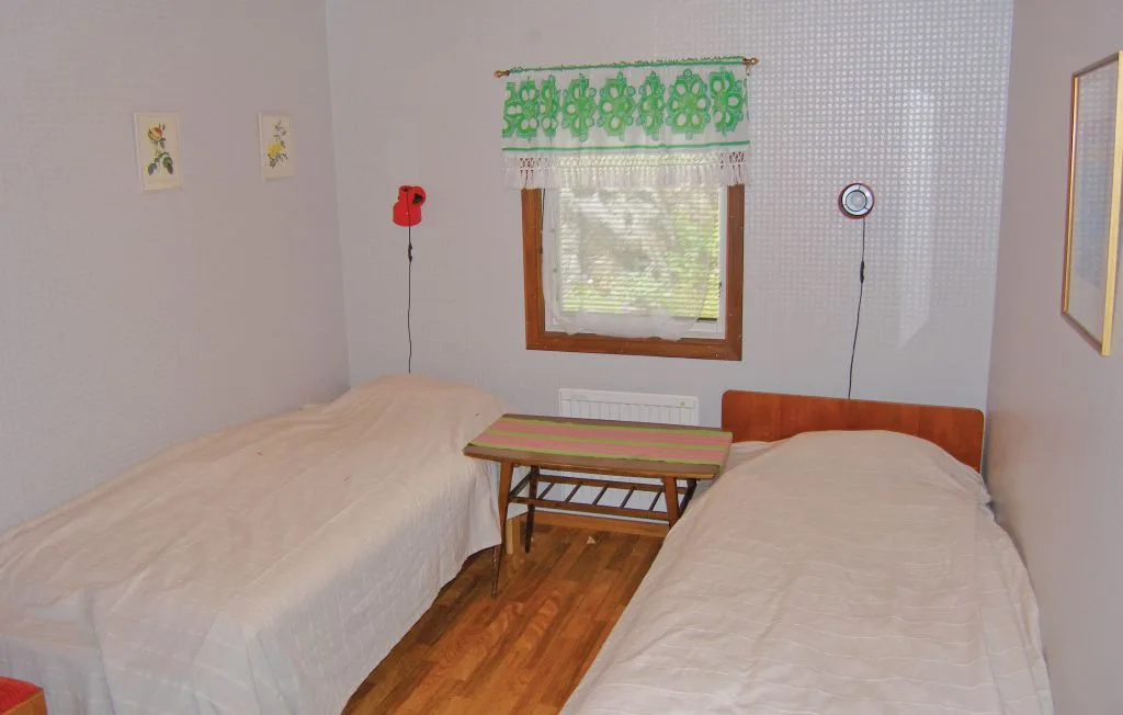 A bedroom with two beds and a small table between them.