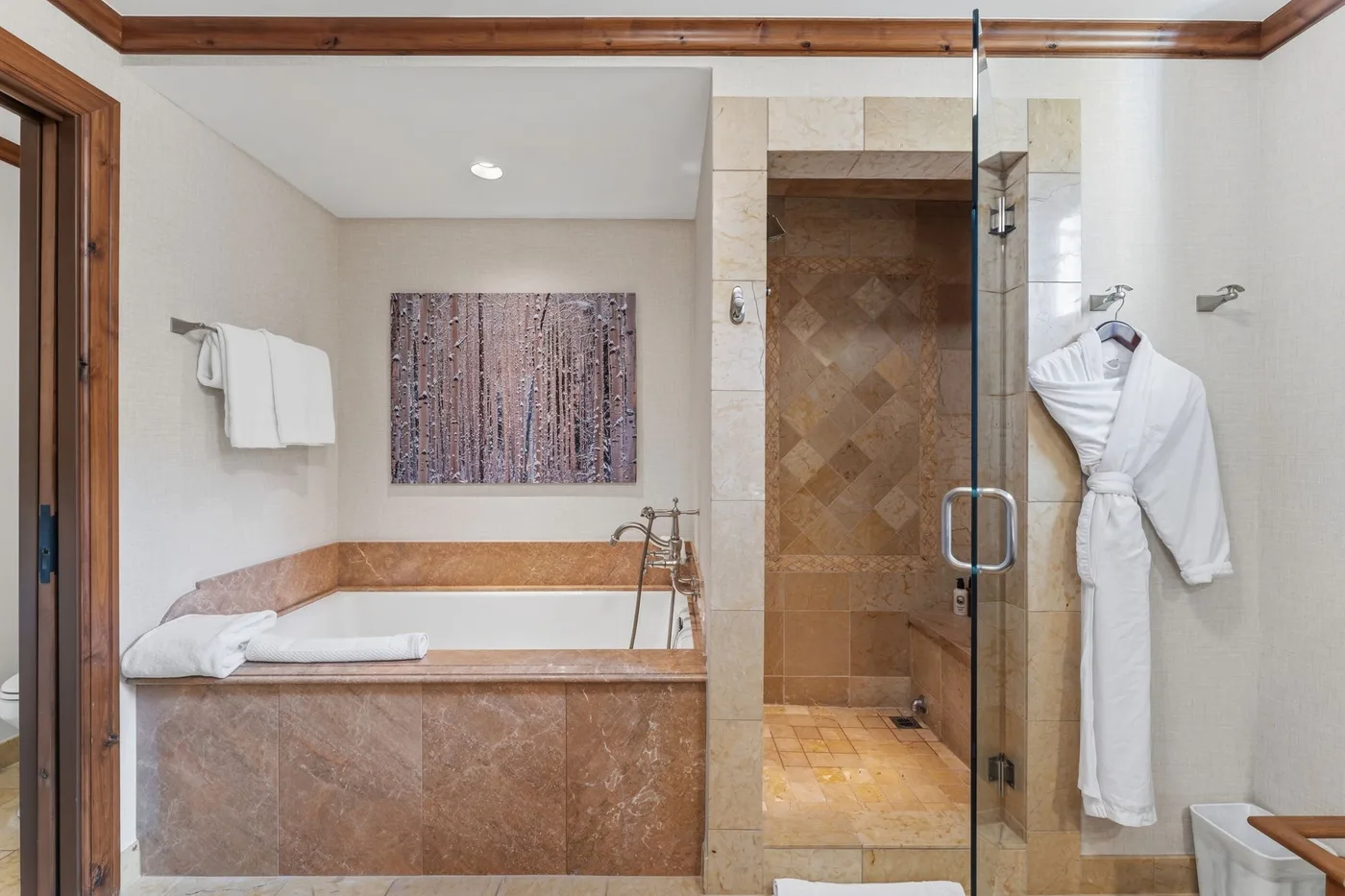Un baño con bañera y una ducha con mampara de vidrio.