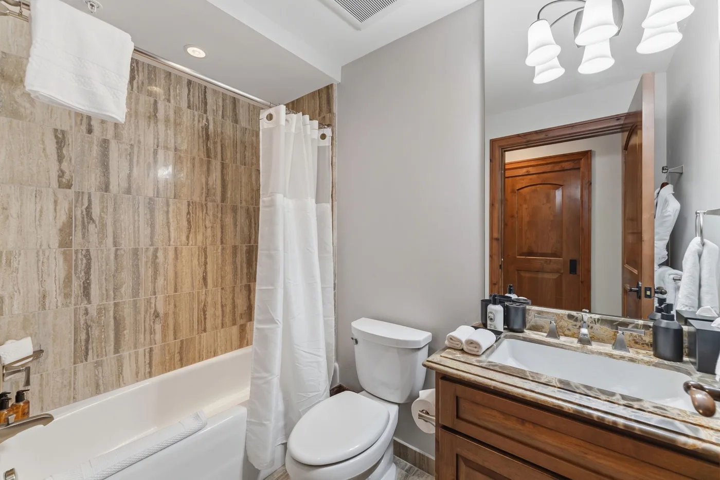 Un baño con bañera, cortina de ducha, inodoro y lavabo.