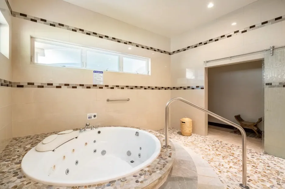 Un baño alicatado con una gran bañera empotrada y una zona de ducha.