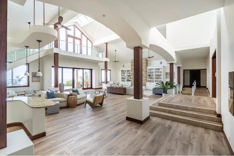 Una amplia sala de estar con asientos, grandes ventanas y una zona elevada.