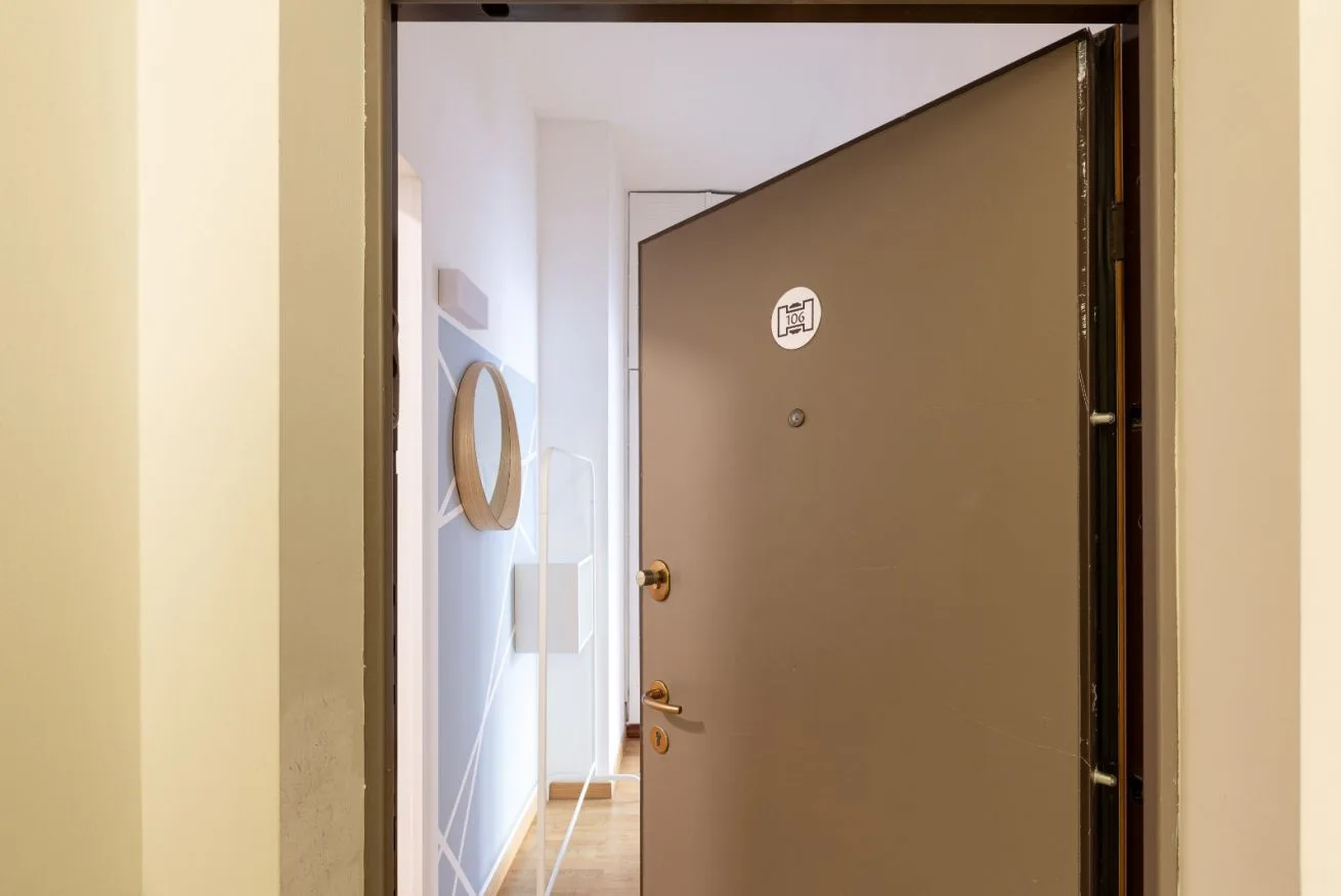 An open entry door reveals a bright interior hallway.