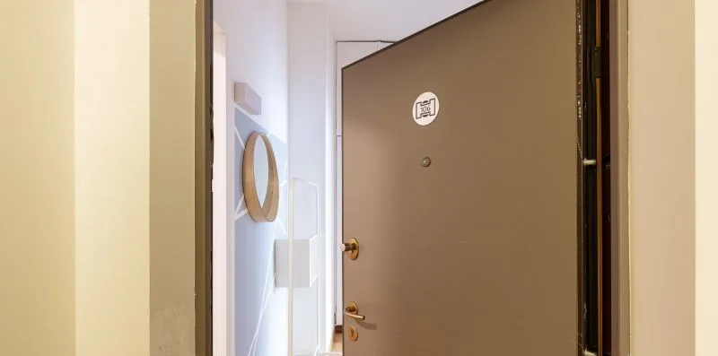 An open entry door reveals a bright hallway.