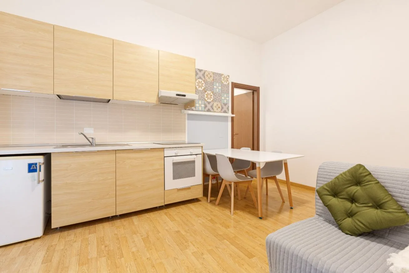 Kitchen and dining area with light wood cabinets and a table.