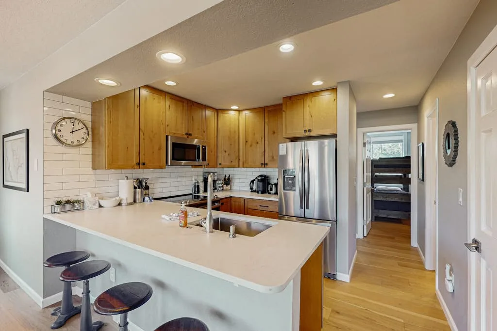 A bright kitchen with wooden cabinets, stainless steel appliances, and a large island.