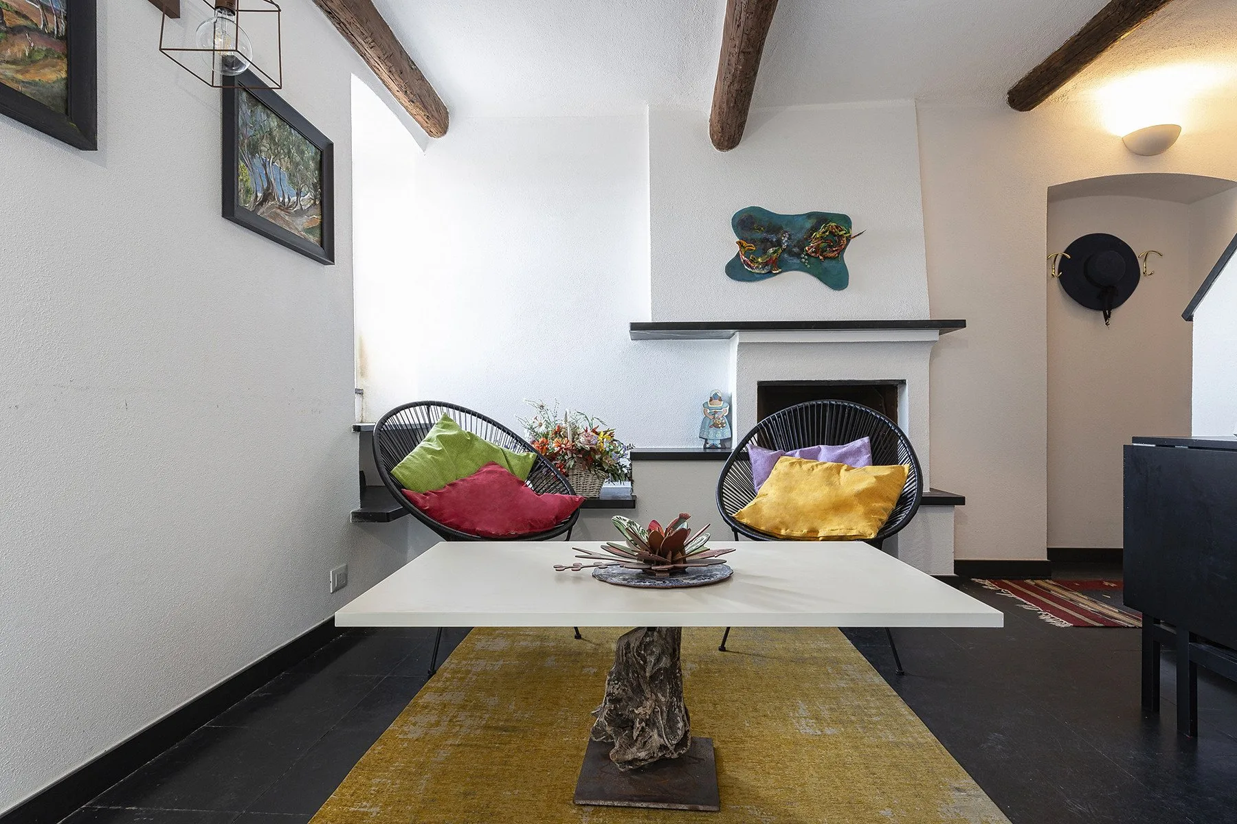 Una luminosa zona de estar con dos sillas redondas alrededor de una mesa baja.