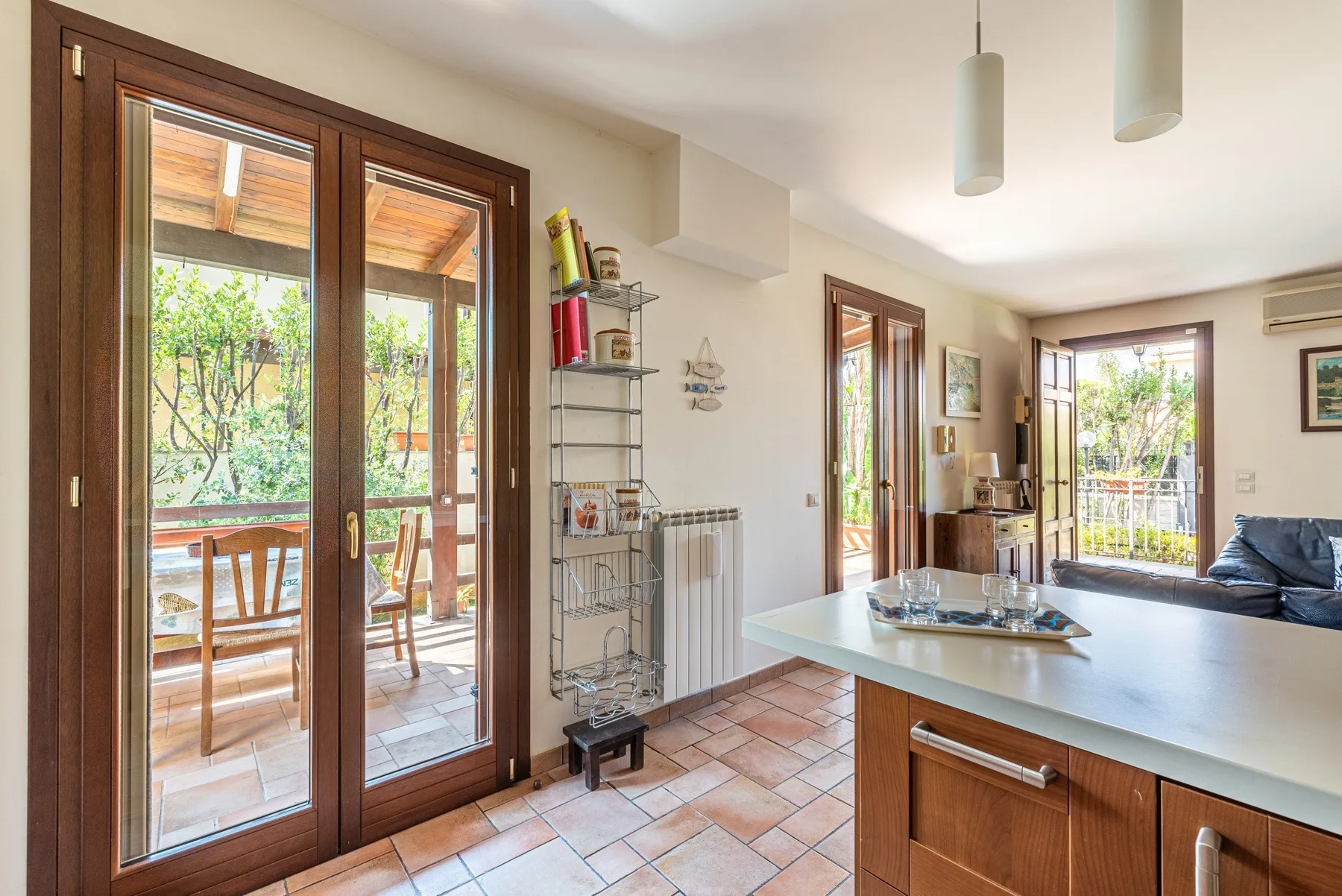 Una luminosa cocina abierta al salón, con grandes puertas de vidrio que dan a un patio.