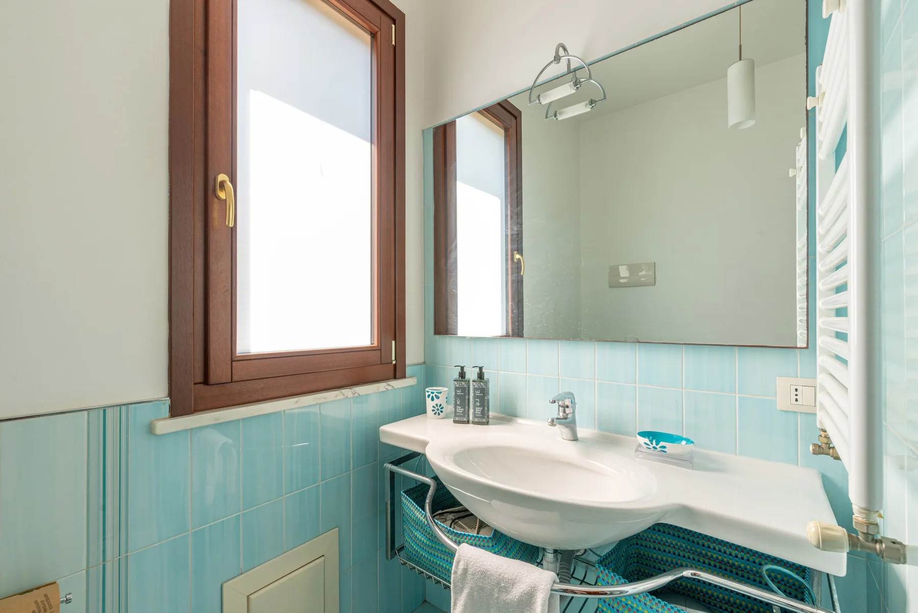 Un baño con un lavabo grande debajo de un espejo de pared.