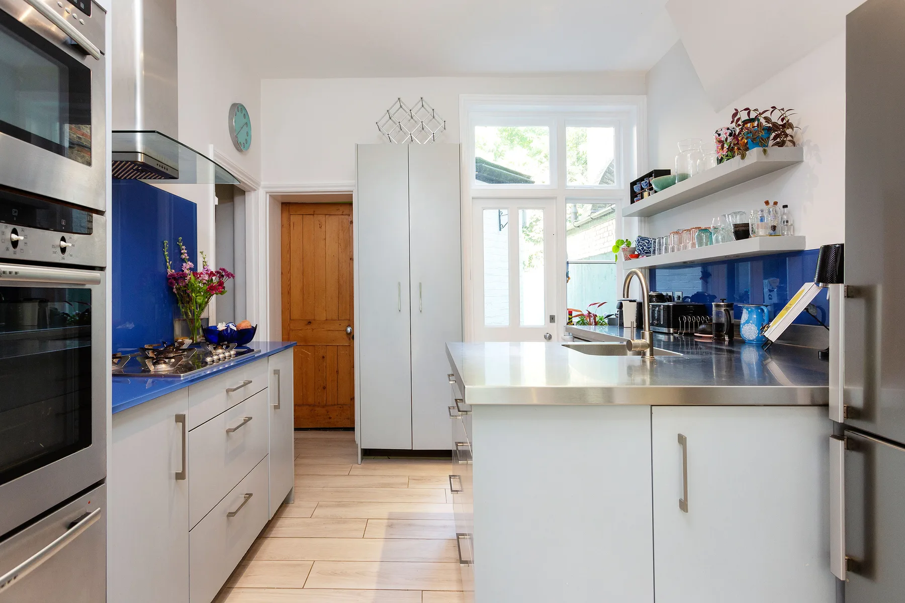 A bright kitchen with blue countertops, white cabinets, and a dining area by the window.