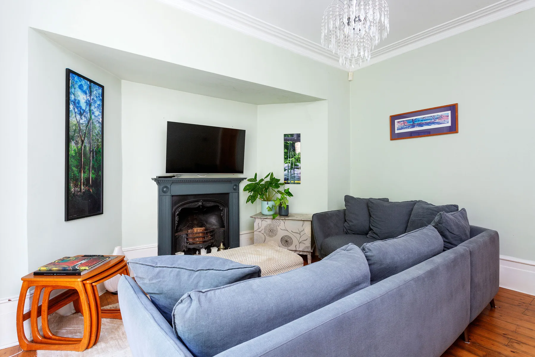 A living room with gray seating, a fireplace, and a television.