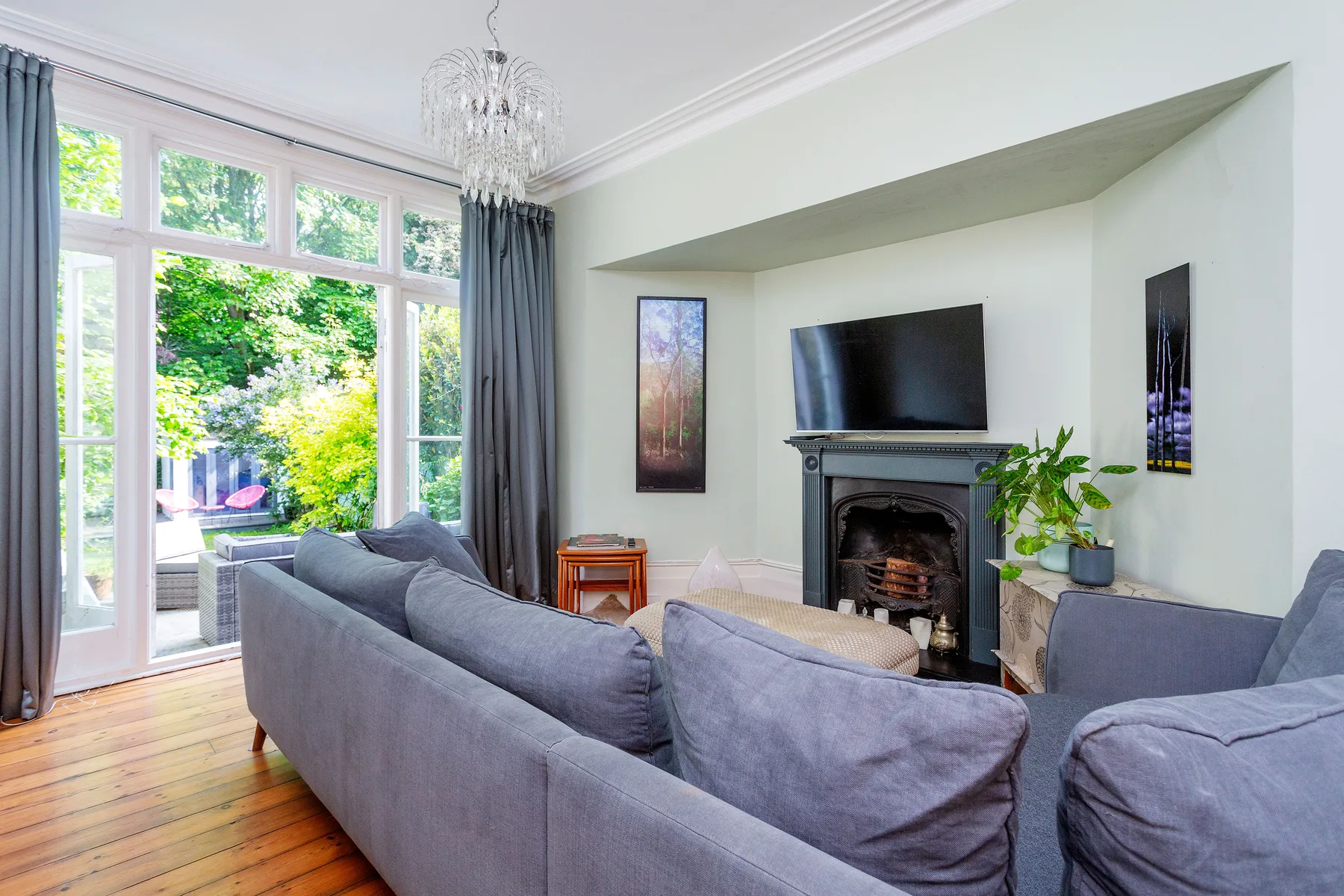 A bright living room with seating facing a fireplace and television.