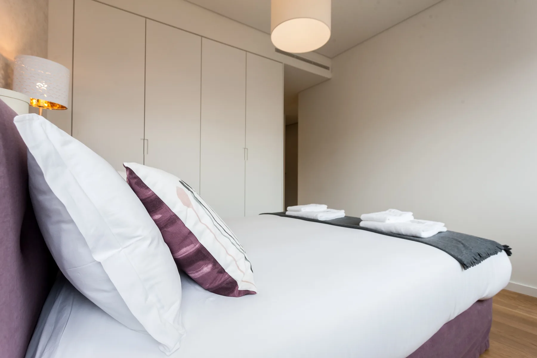 Un dormitorio con una cama bien hecha y toallas dobladas.