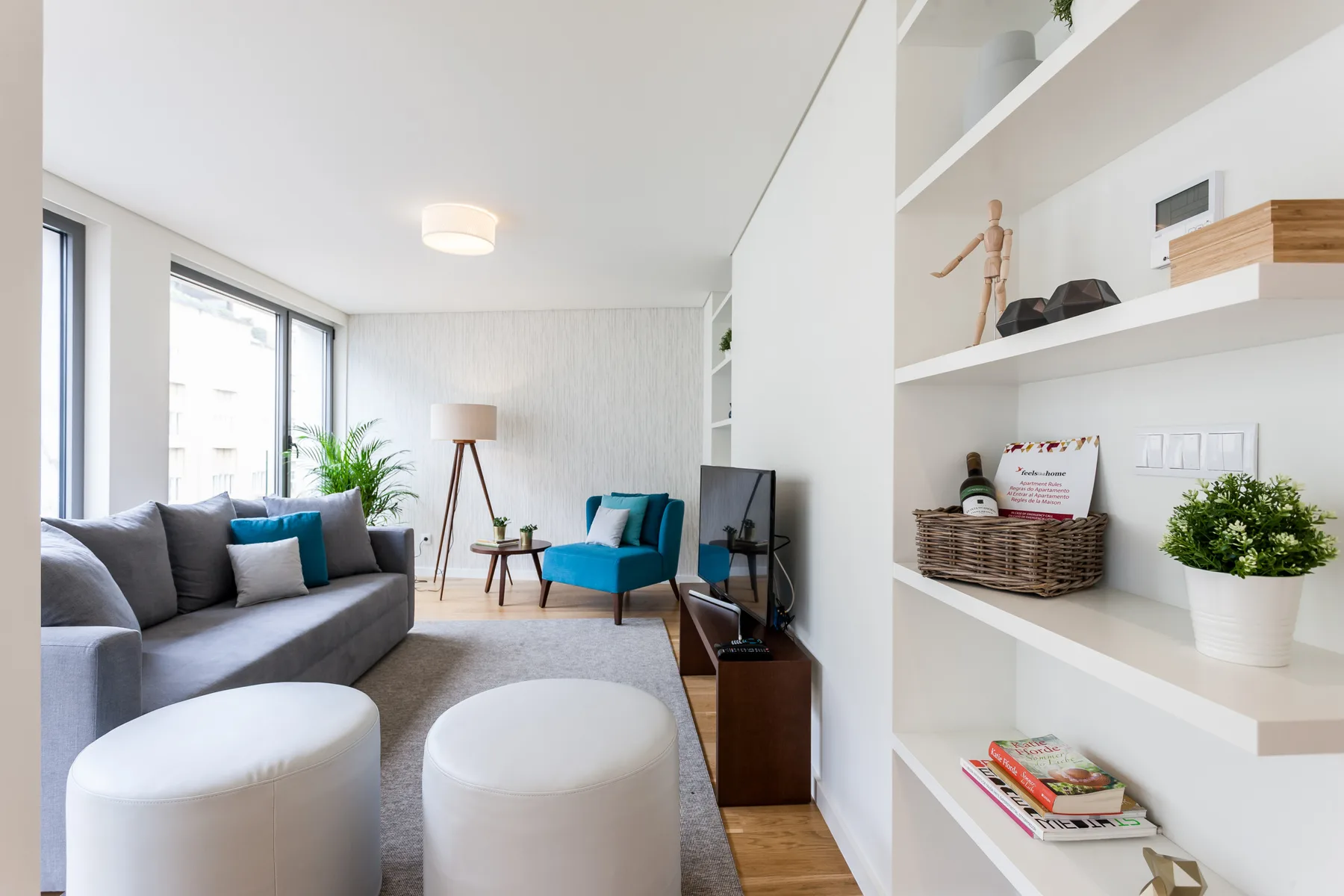 Una sala luminosa con asientos junto a grandes ventanas y estantes empotrados.