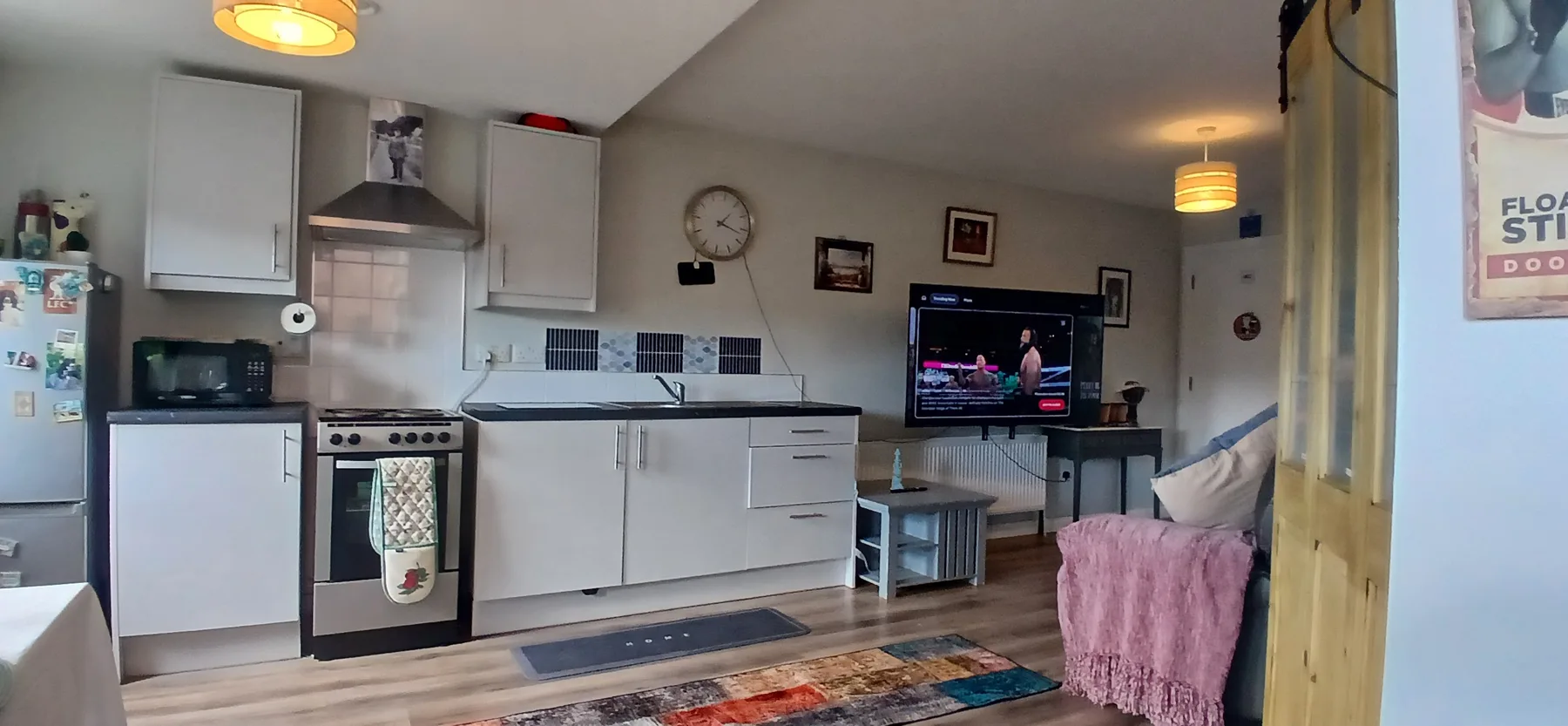 A compact kitchen and dining area with a television and seating.