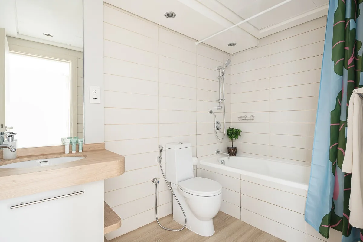 Un baño luminoso con bañera, ducha y lavabo.