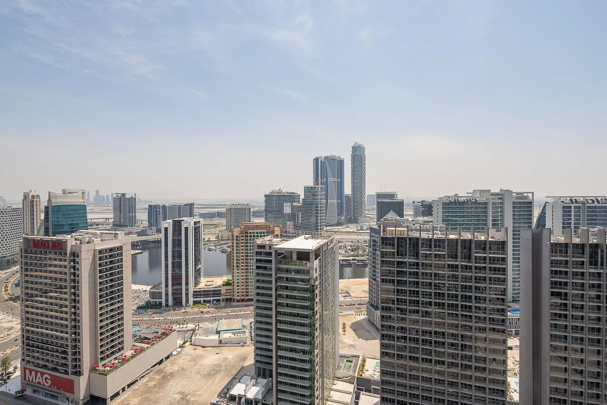 Horizonte urbano con edificios altos bajo un cielo parcialmente nublado.