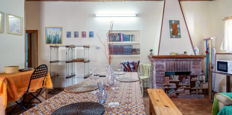 Un comedor con un mantel estampado y una chimenea de ladrillo.