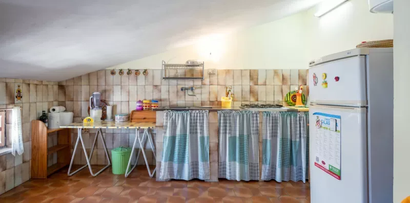 Una cocina con pared de azulejos, encimera y refrigerador.