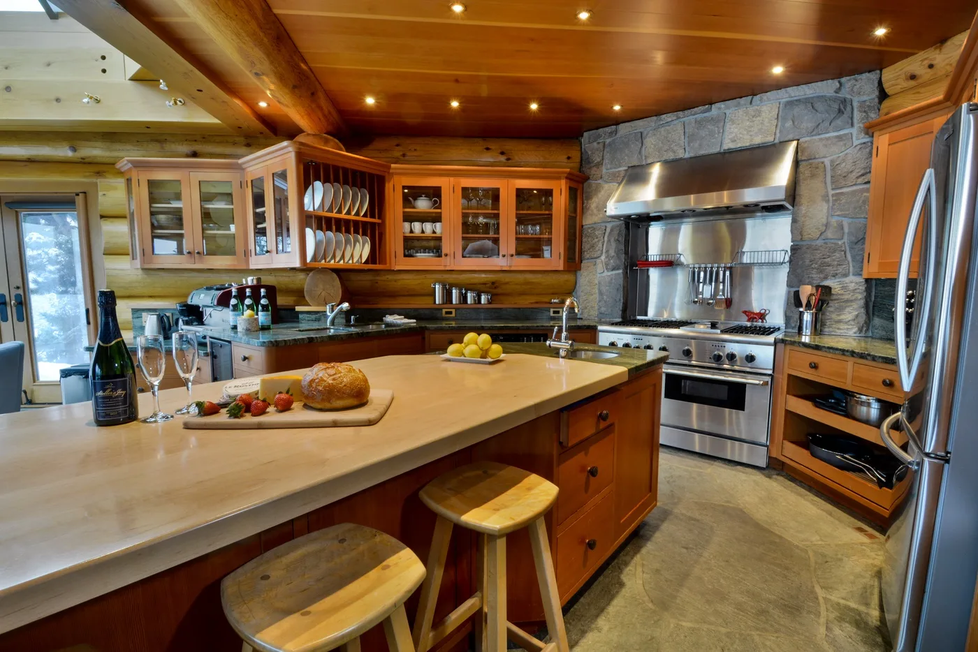 A spacious kitchen with wooden cabinetry, a large island, and stainless steel appliances.