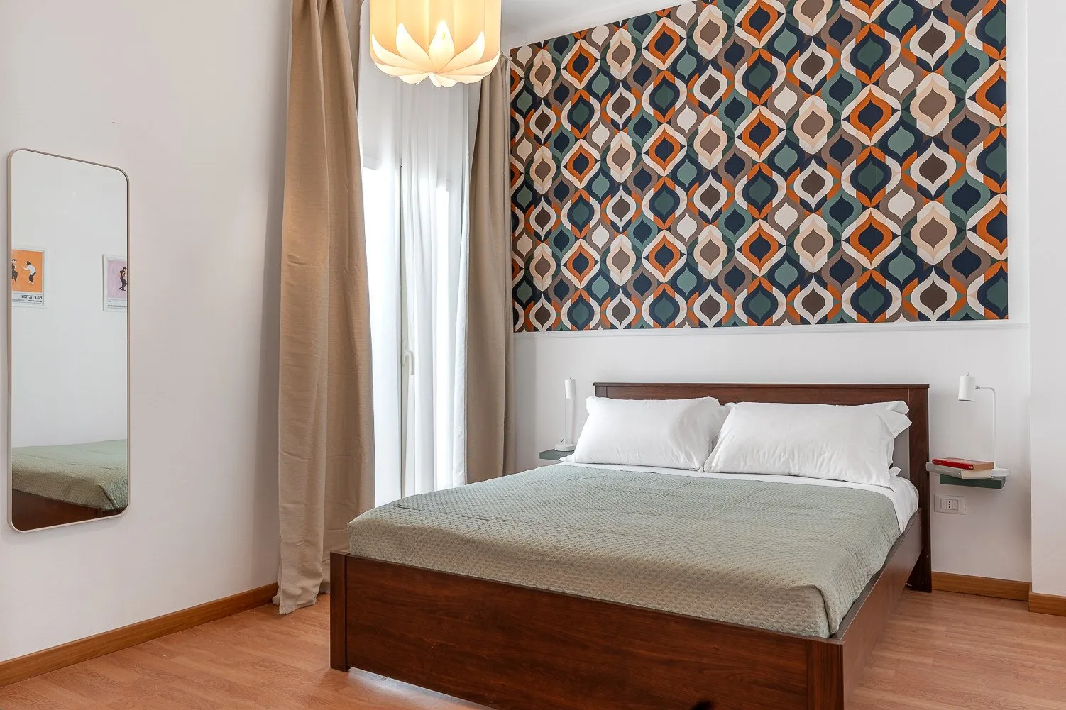 Un dormitorio con una cama de madera bajo un cuadro geométrico colorido.