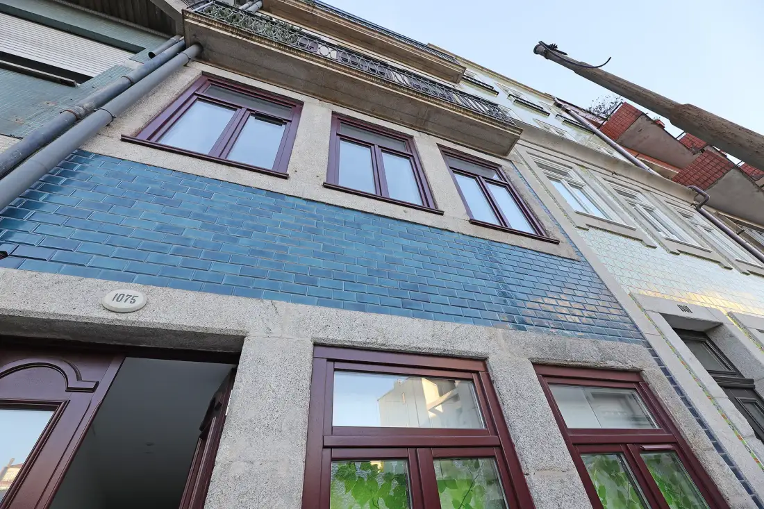 Exterior view of a building with blue tile cladding and rows of windows.