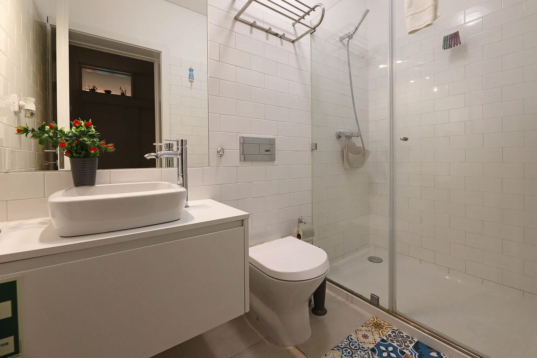 A tiled bathroom with a sink, toilet, and glass shower.
