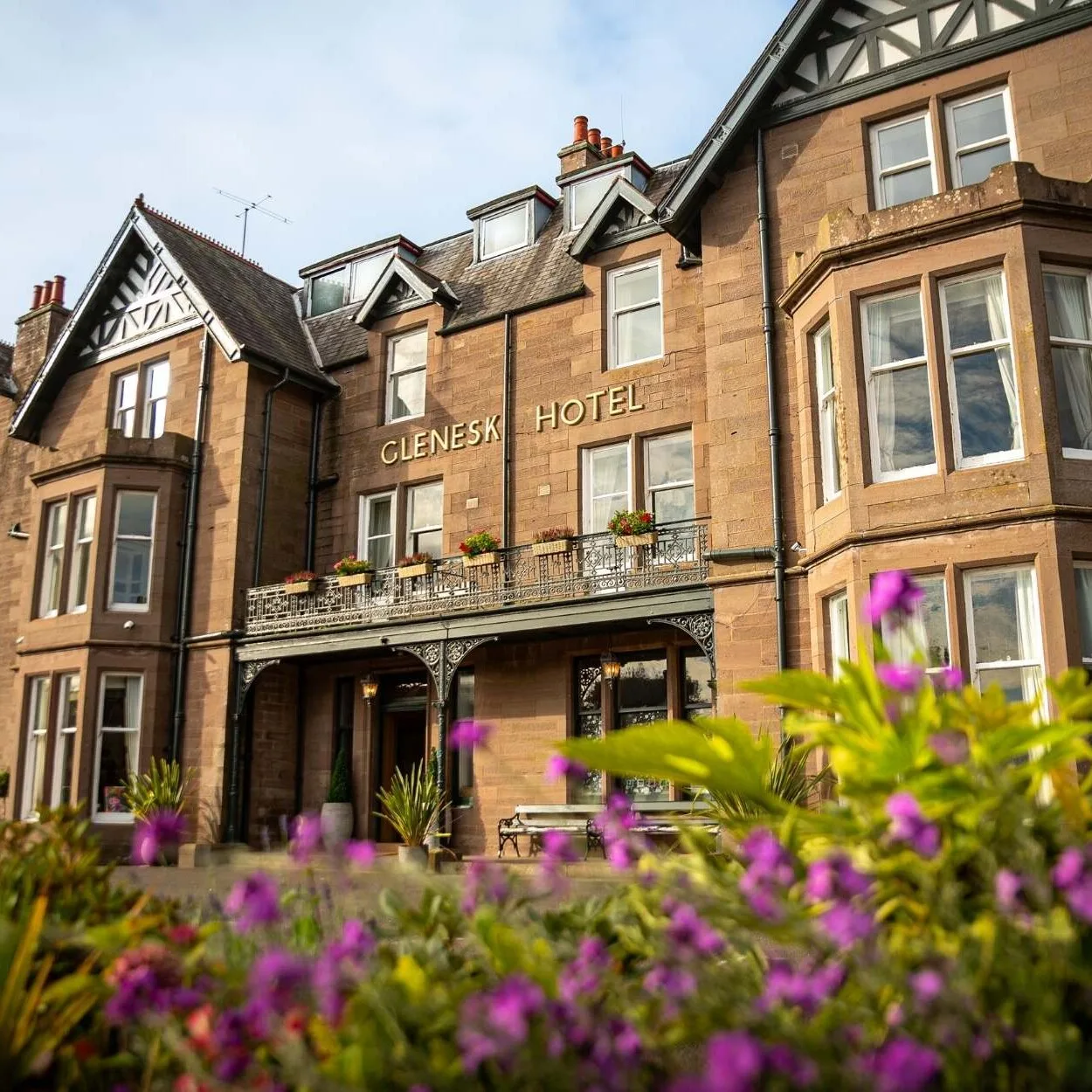 Exterior de la fachada del Glenesk Hotel con flores