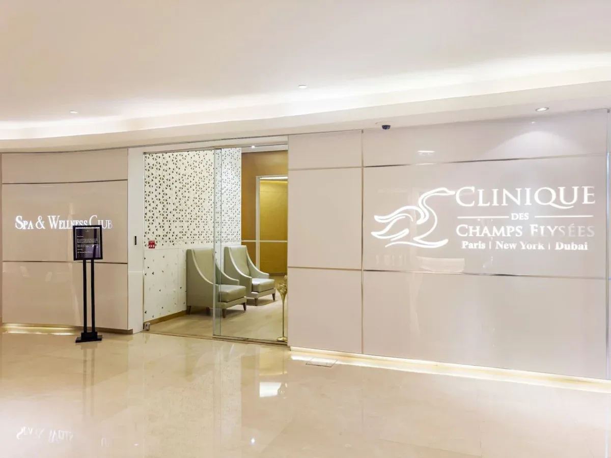 A spa and wellness center entrance with illuminated wall signage and a seating area.
