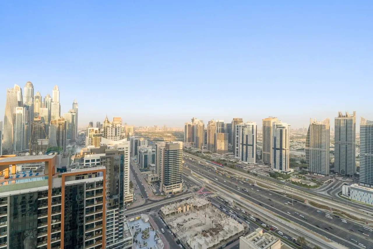 A city skyline with high-rise buildings along a broad highway.