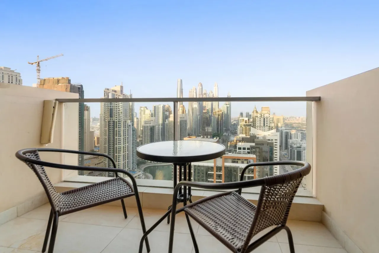 A balcony seating area overlooks a city skyline.