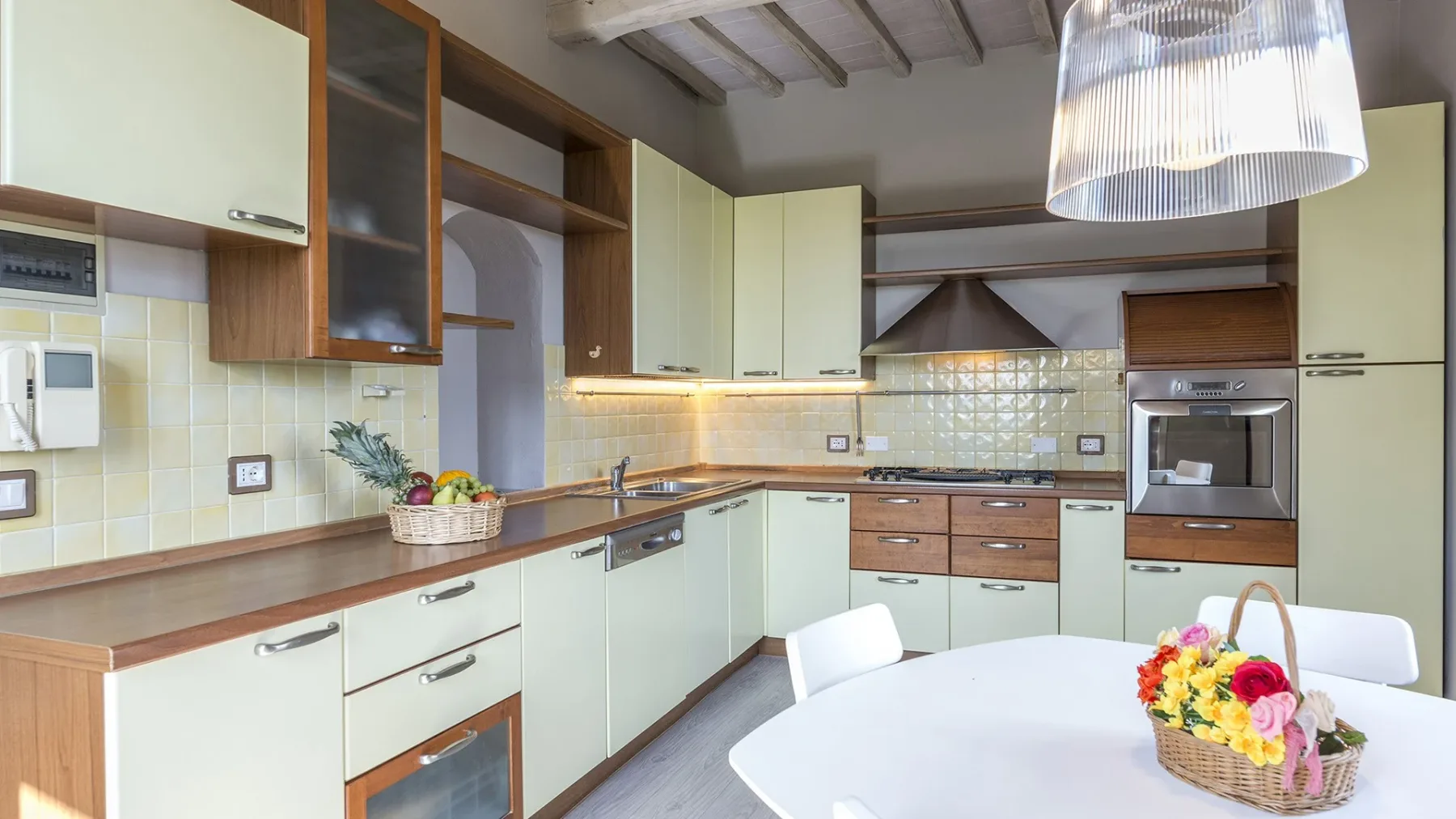 Una cocina luminosa con armarios, una encimera y una mesa de comedor.
