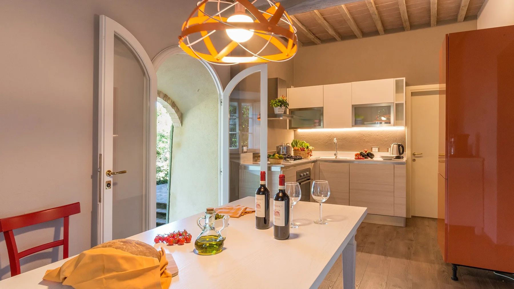 Una cocina luminosa con una mesa larga preparada con copas de vino.