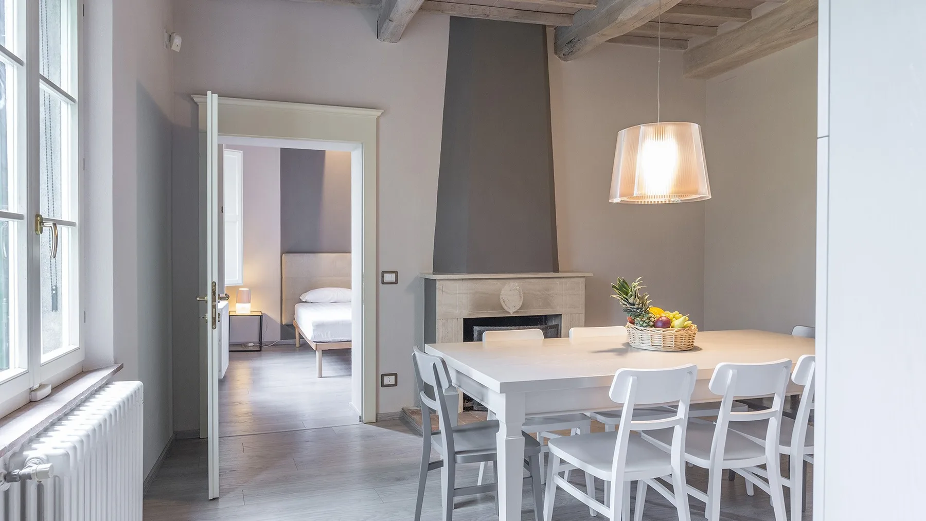 Un comedor con una mesa blanca y sillas junto a una puerta abierta.