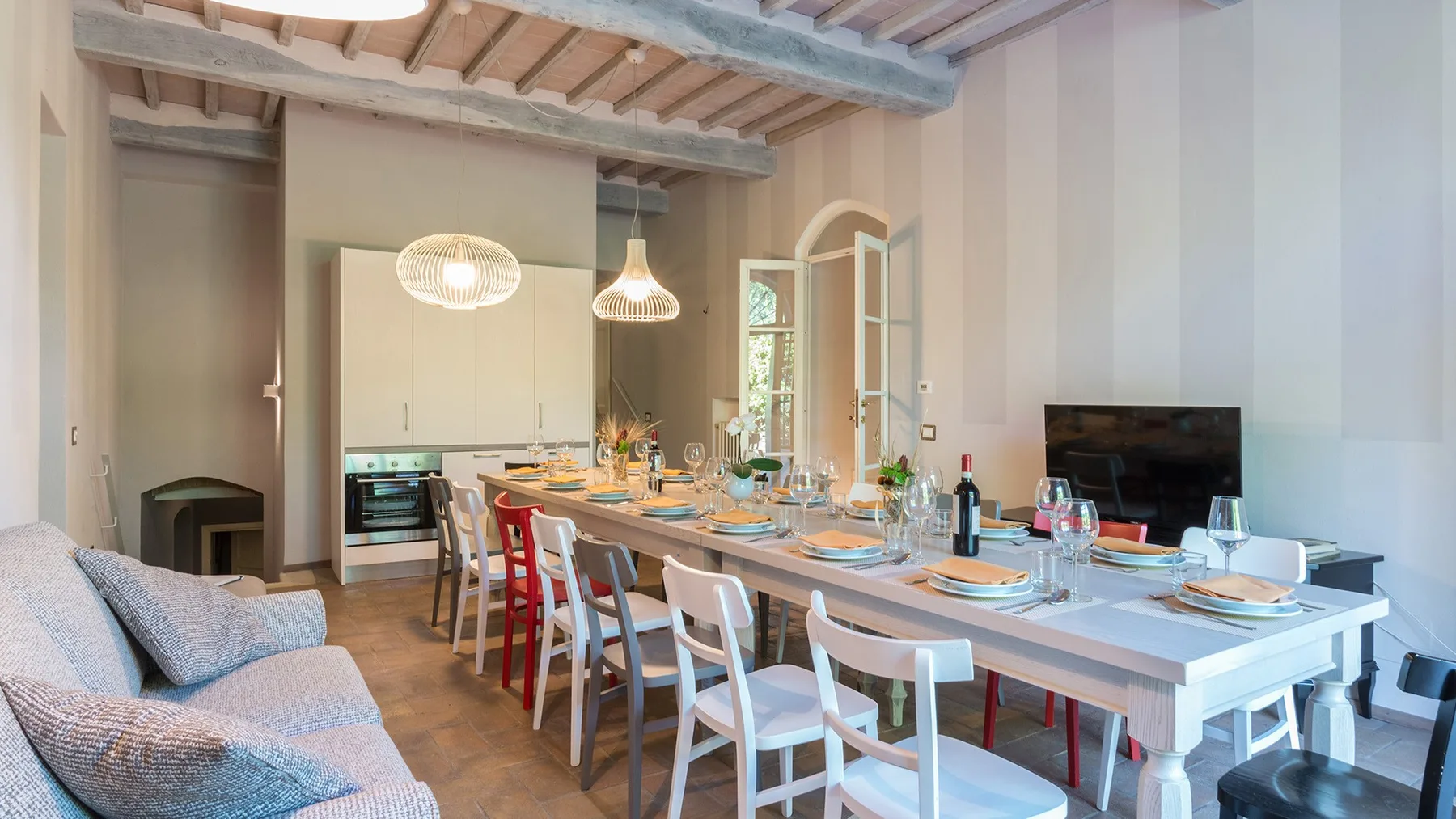 Comedor con una mesa larga puesta junto a una zona de estar.