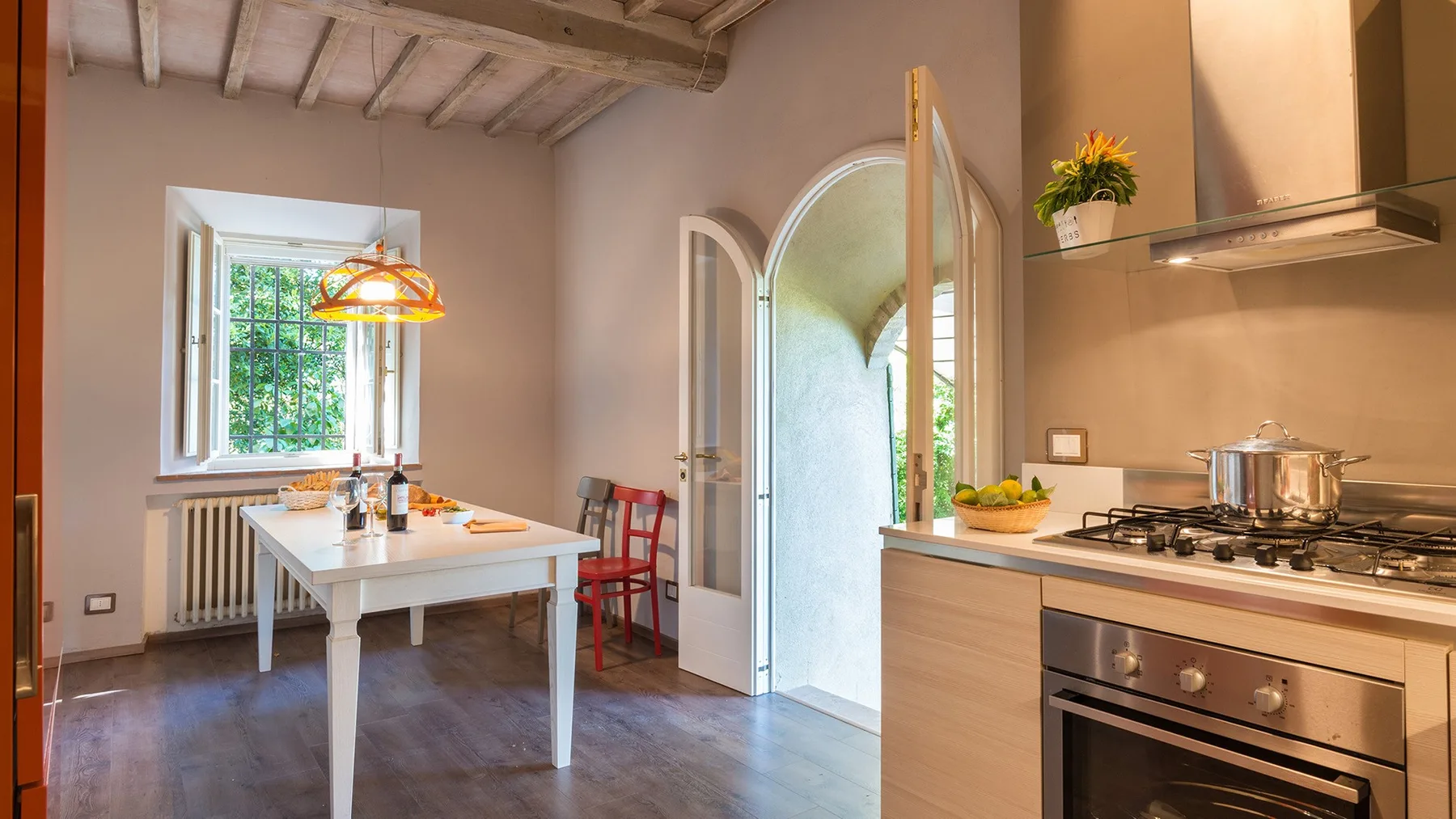 Una cocina y comedor con una mesa junto a una ventana y una estufa.