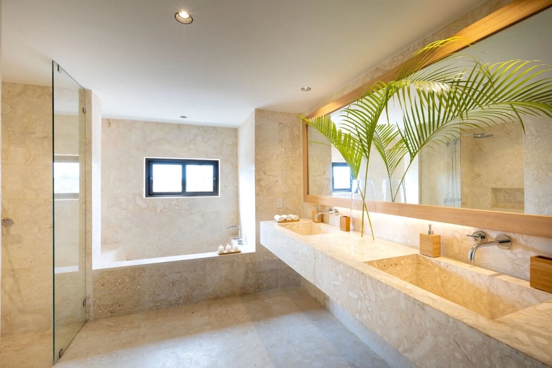 A spacious bathroom with a long stone vanity and a large mirror.