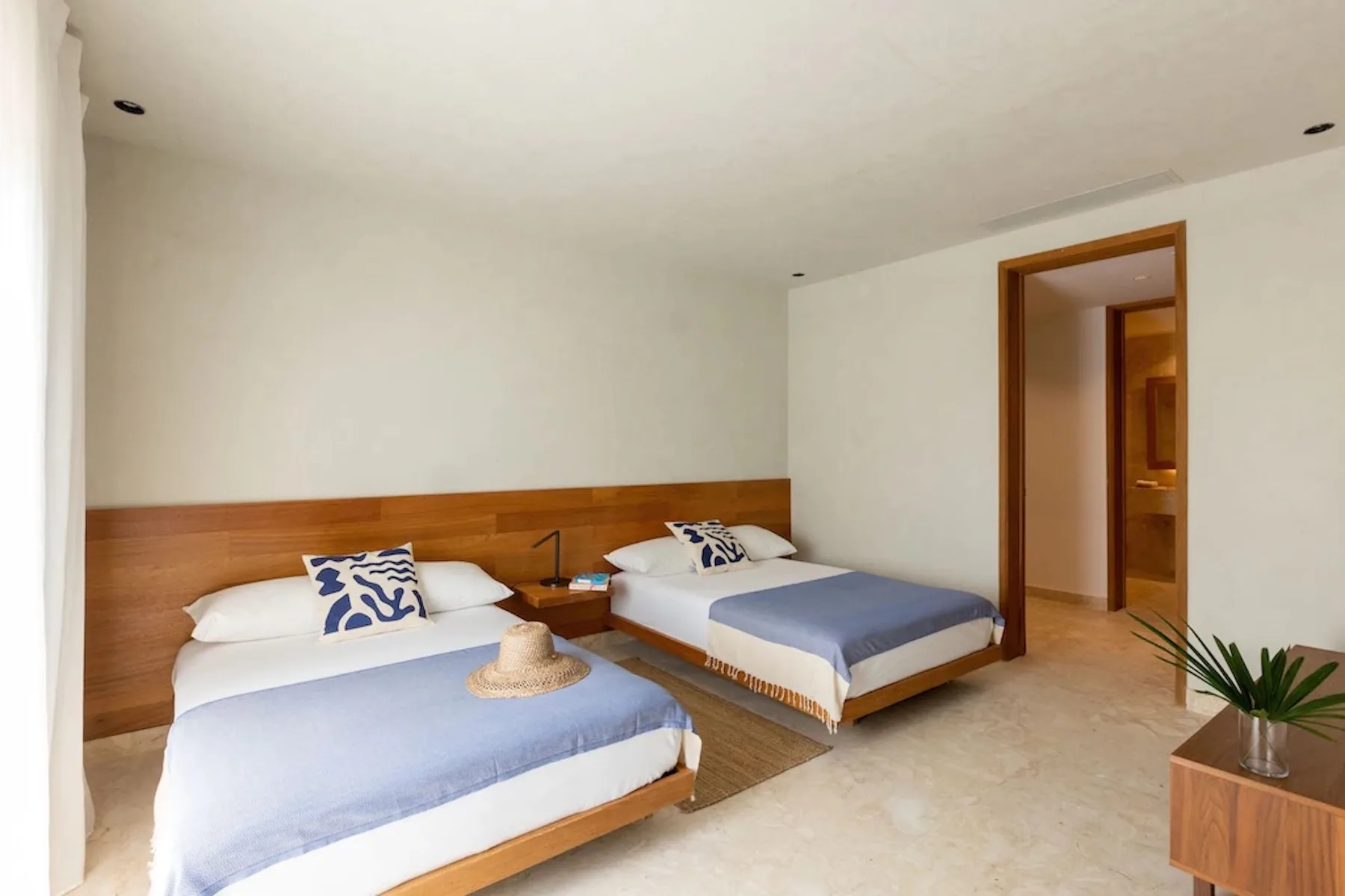 A bedroom with two beds, each topped with light blue bedding.