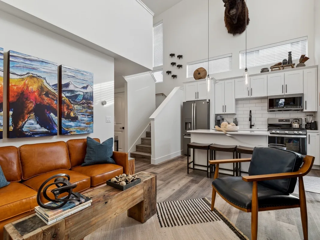 Sala de estar y cocina de concepto abierto con arte colorido en la pared y una isla.