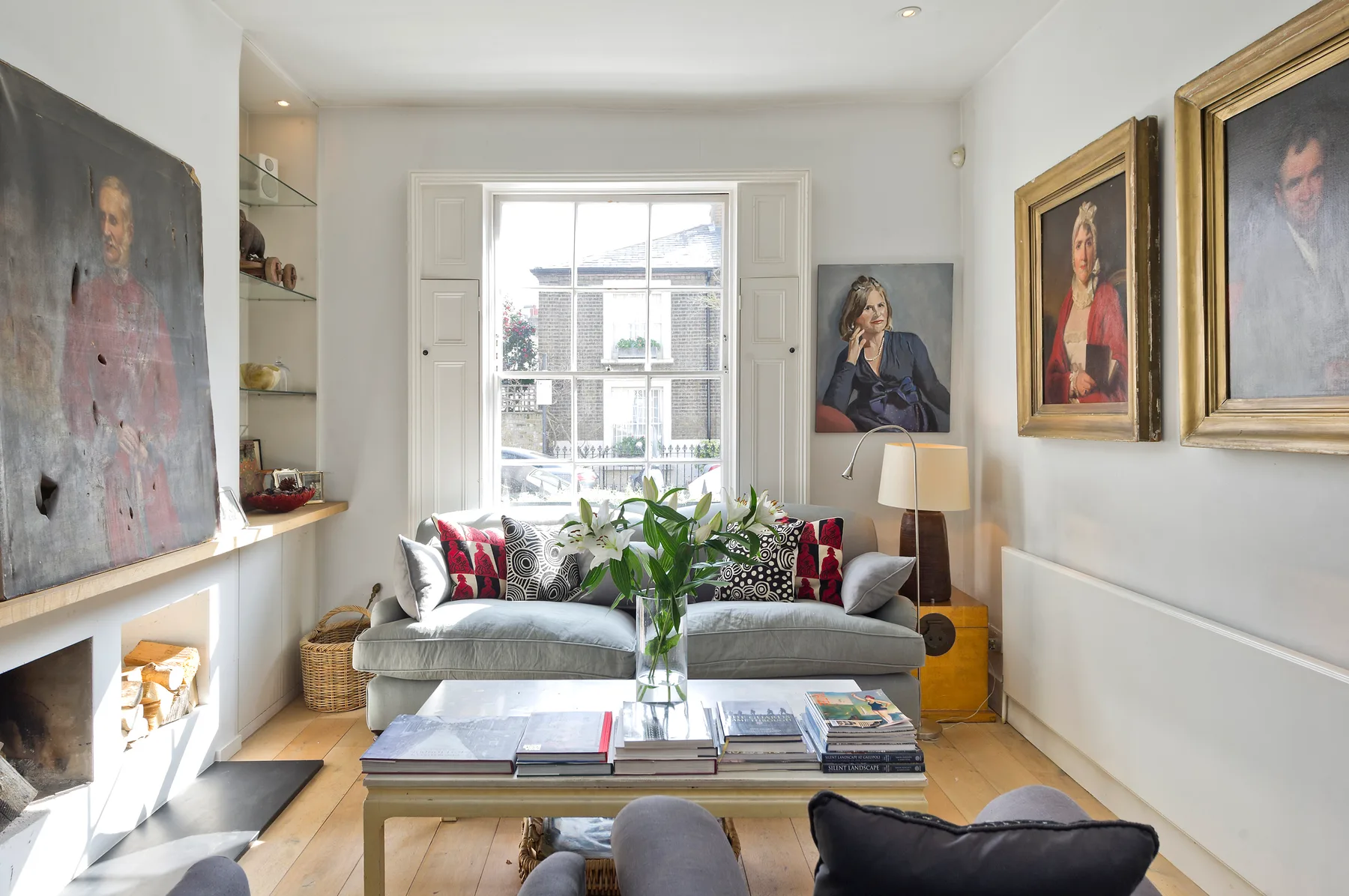 Una sala luminosa con asientos alrededor de una mesa baja junto a una ventana amplia.