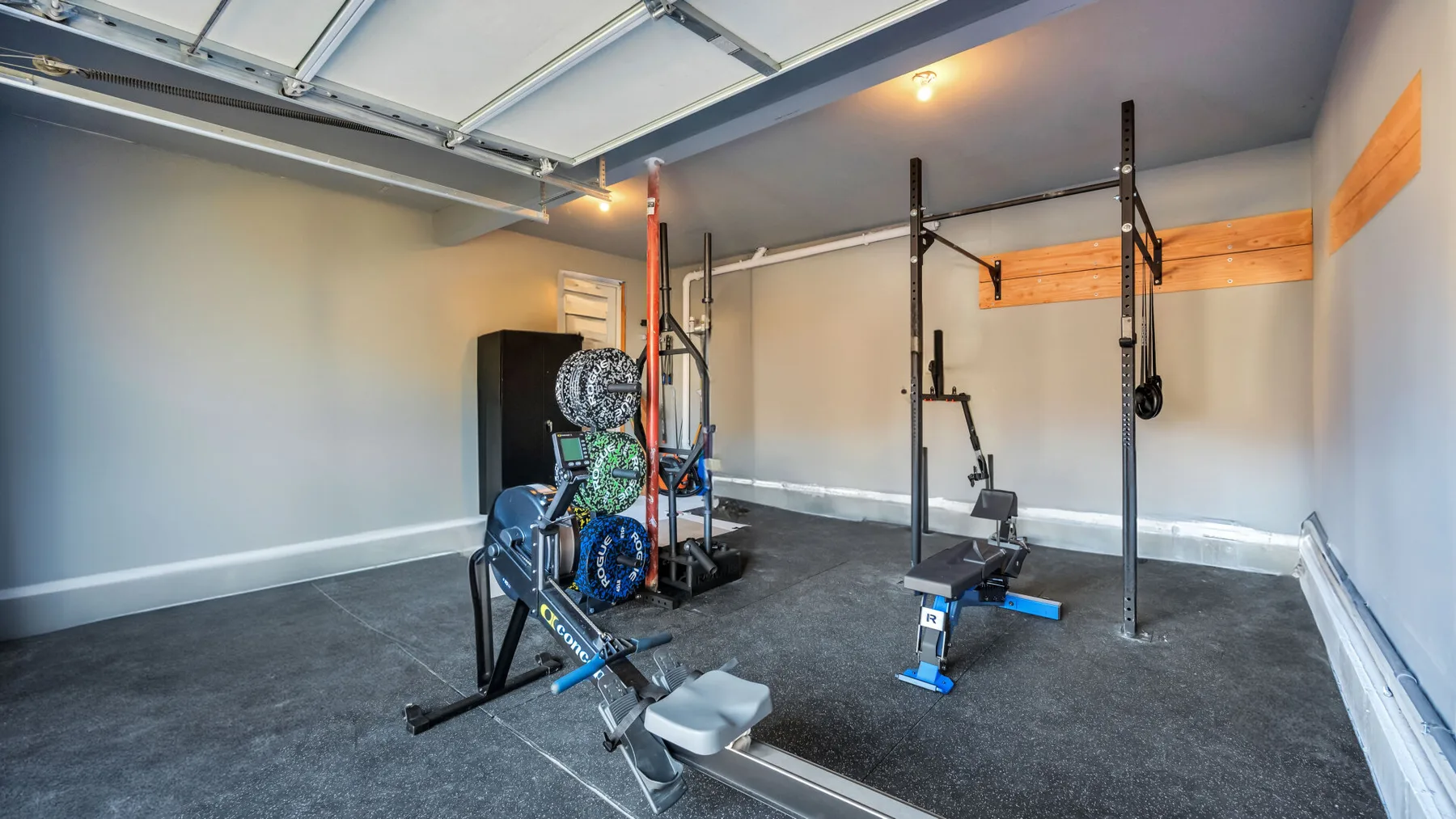 A home gym with exercise equipment and a weightlifting rack.