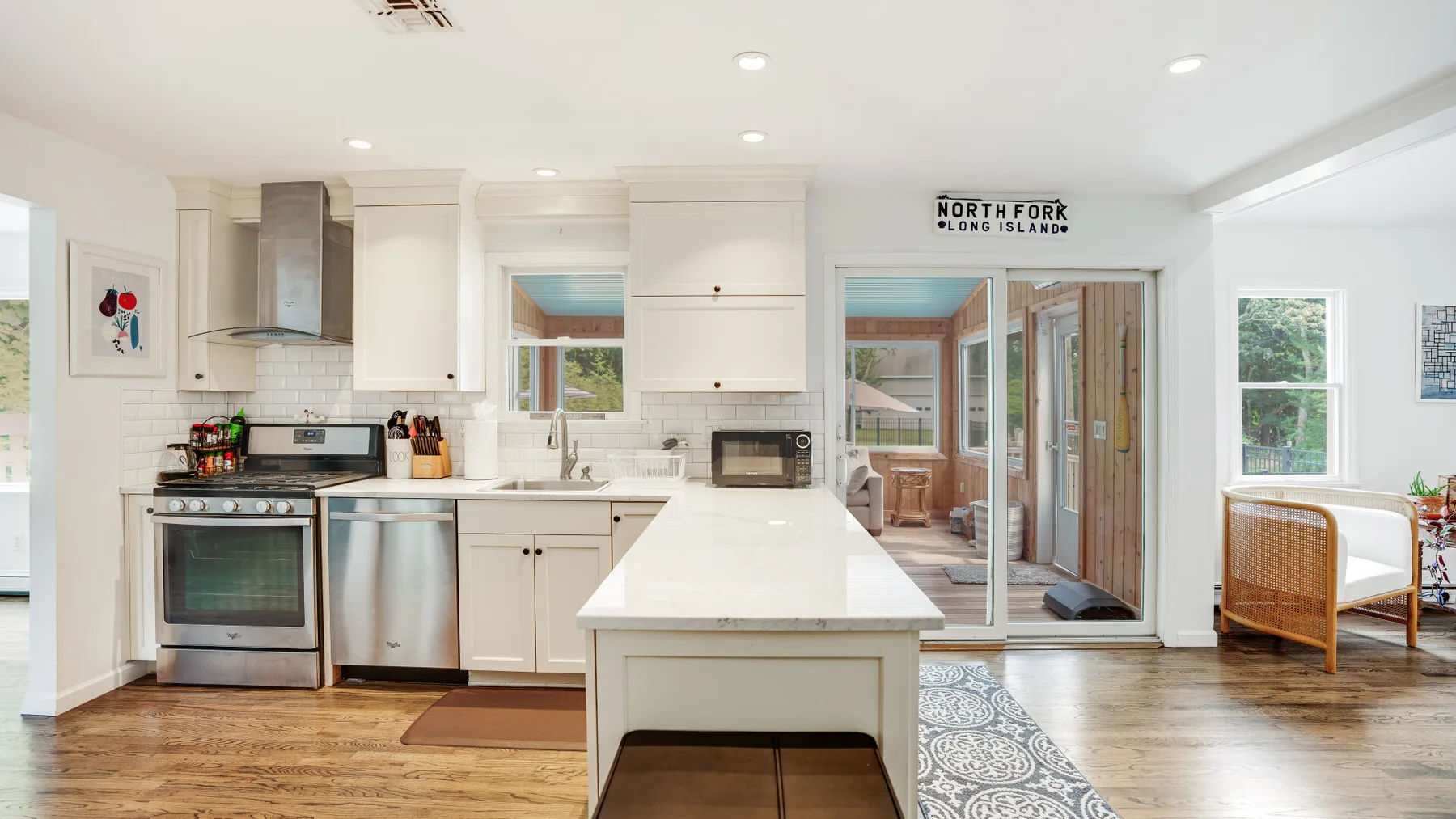 A bright kitchen with a central island and cooking area.
